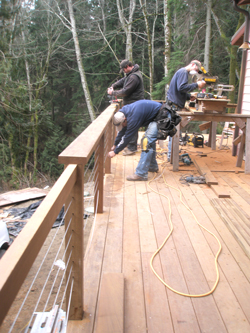 Workers cutting wood and assembling the deck rails